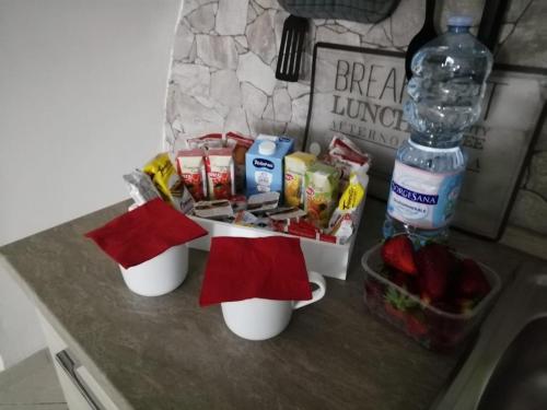 un bancone della cucina con due tazze e una bottiglia d'acqua di Montesantogroup Apartments a Napoli