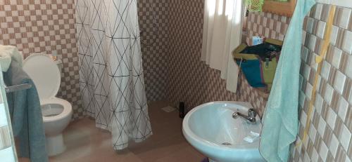 a bathroom with a sink and a toilet at Campement Sindéye in Abémé