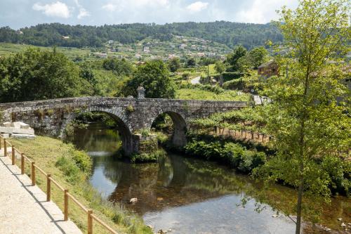 an old stone bridge over a river at Casa da Veiga in Aldeia