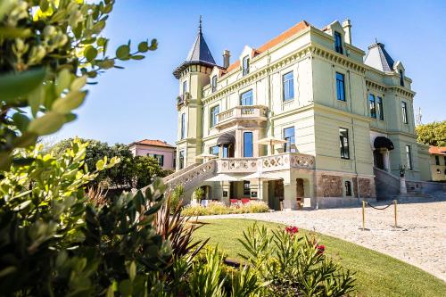 a large white house with a blue roof at Vila Foz Hotel & SPA - member of Design Hotels in Porto