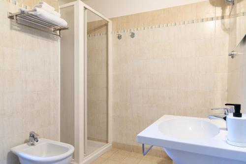 a white bathroom with a sink and a shower at Fox House BnB in LʼAquila