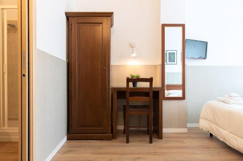 a bedroom with a desk with a chair and a mirror at Fox House BnB in LʼAquila