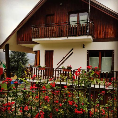 a house with a balcony and red flowers at LA ROCCA BIANCA in Demonte