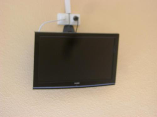 a flat screen tv hanging on a wall at Hôtel La Casera in Clarac
