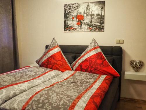 1 dormitorio con 1 cama con almohadas rojas y grises en Dorfidylle - Thüringer Wald Rennsteig, en Friedrichroda