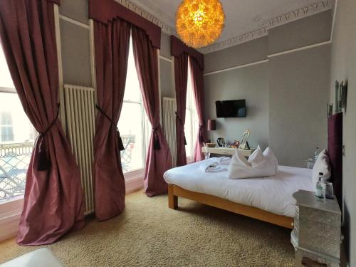 a bedroom with a large bed and a large window at The Oriental - Guest House in Brighton & Hove