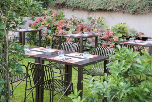 a group of tables and chairs with wine glasses on them at Mercure Milano Agrate Brianza in Agrate Brianza