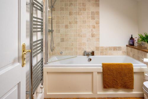 a bathroom with a bath tub and a shower at Magnolia Cottage in Church Stretton