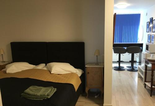 a bedroom with a bed and two chairs and a window at Rødby Købstadshotel in Rødby