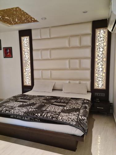 a bed in a room with two windows at Hotel Star Inn in Gangānagar