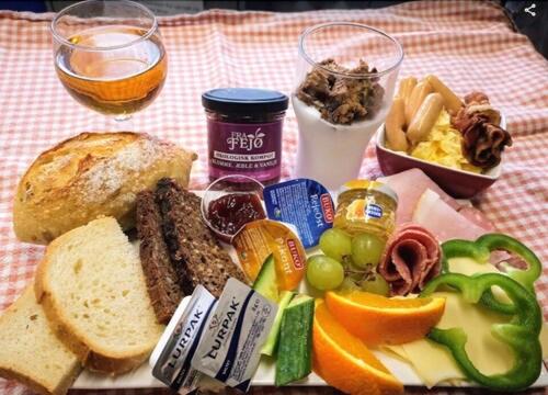 a plate of food on a table with bread and fruit at Rødby Købstadshotel in Rødby