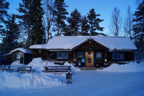 una cabaña de madera con nieve en la parte delantera en Husvagn i Hundfjället Sälen en Sälen