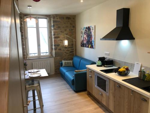 un salon avec un canapé bleu dans une cuisine dans l'établissement Appartement en duplex centre-ville BOHEME, à Vannes