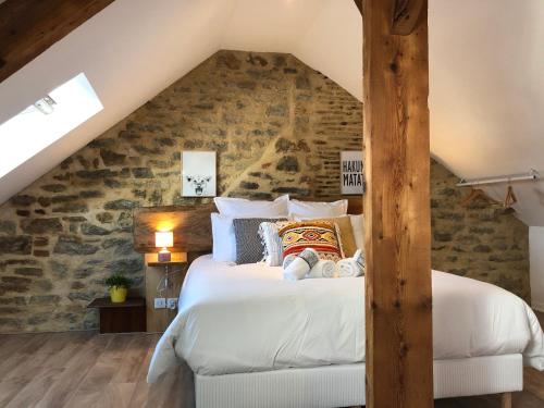 - une chambre avec un grand lit et un mur en pierre dans l'établissement Appartement en duplex centre-ville BOHEME, à Vannes