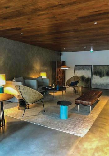 a living room with chairs and a couch and tables at Lux Lisboa Park in Lisbon