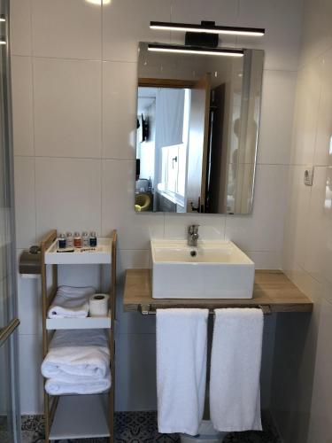 a bathroom with a sink and a mirror and towels at Hotel Finca Alcamino in Mompía