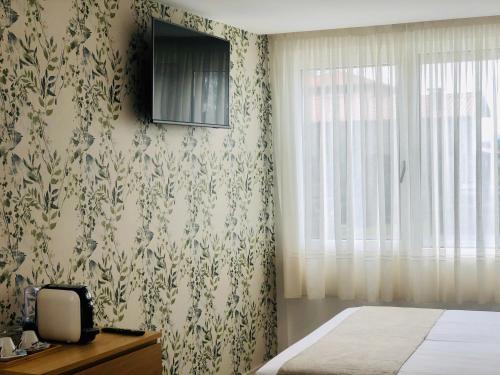 a bedroom with a bed and a tv on the wall at Hotel Finca Alcamino in Mompía