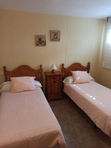 um quarto com 2 camas e uma mesa com um candeeiro em Alojamiento rural "LA JARA" em Robledillo de la Jara