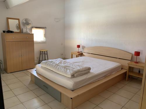 une chambre avec un lit et deux tables et une fenêtre dans l'établissement Appartement en duplex à 400 m de la plage dans résidence avec piscine commune 1 chambre 4 couchages WIFI LXOND47, à Portiragnes