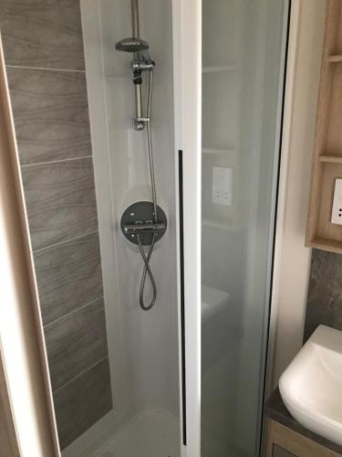 y baño con ducha y puerta de cristal. en Valley View with a luxurious hot tub, en Newquay