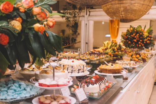 a table topped with lots of different types of cakes at Pratagy Acqua Park Beach All Inclusive Resort - Wyndham in Maceió