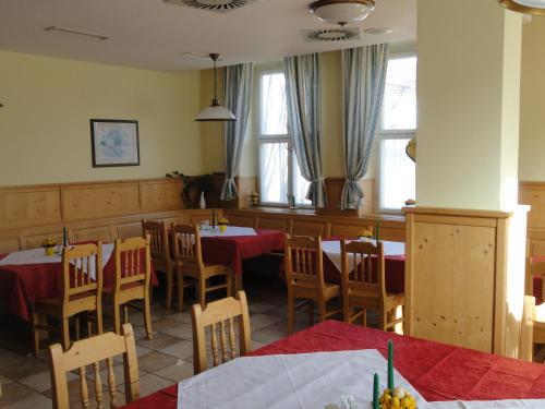 a dining room with tables and chairs and windows at Ennstalerhof in Grossraming