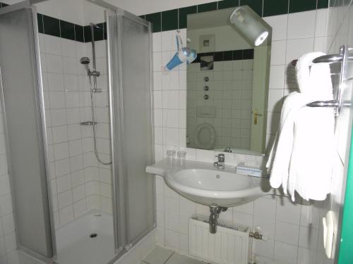 a white bathroom with a sink and a shower at Ennstalerhof in Grossraming