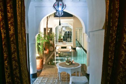 pasillo de una casa con mesa y espejo en Riad Golfame, en Marrakech
