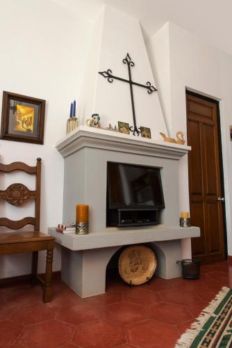 a living room with a fireplace with a tv at Casa Estrella de la Valenciana Hotel Boutique in Guanajuato