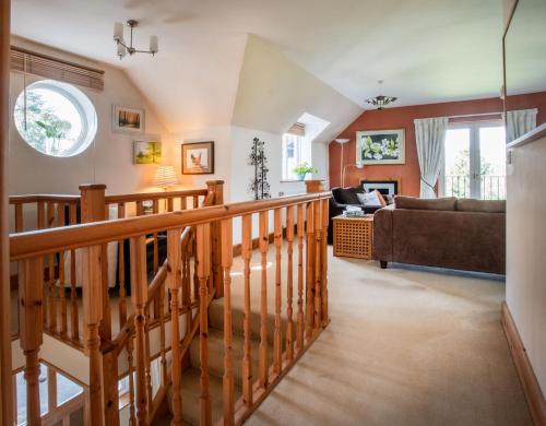 a living room with a staircase and a couch at Berries Coach House in Church Stretton