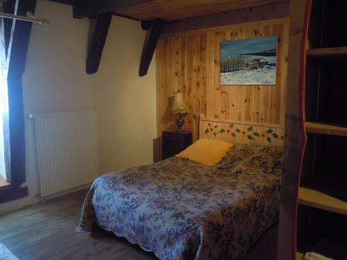 a bedroom with a bed in a room with wooden walls at Gite Le Francillon in Les Estables