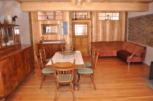 a dining room with a table and chairs and a couch at Czarnotka in Mirsk