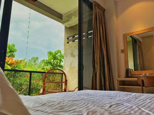 a bedroom with a bed and a balcony with a view at Harmony Valley Retreat in Bukit Tinggi