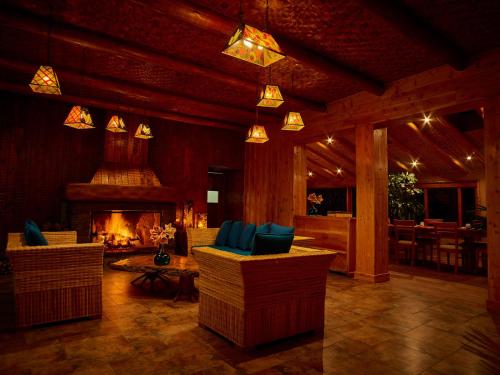sala de estar con sillas y chimenea en Hosteria Cabañas Del Lago, en Otavalo