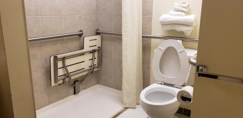 a bathroom with a toilet and towels in it at Family Budget Inn in Bethany