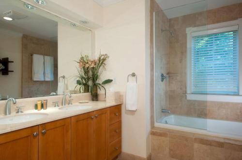 a bathroom with a tub and a sink and a mirror at Villa Renaissance Unit 501 Grace Bay Beach in The Bight Settlements