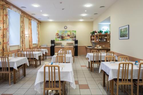 a restaurant with tables and chairs and a kitchen at Hotel Admiral in Vienna