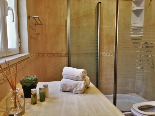 a bathroom with a shower and towels on a counter at Moradia Pinhal da Telha in Corroios