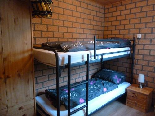 2 Etagenbetten in einem Zimmer mit Ziegelwand in der Unterkunft Vacation home Zwaantje #BL66 in Callantsoog