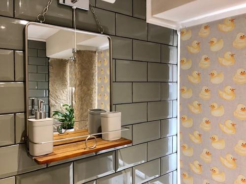 ein Badezimmer mit einem Spiegel an einer Backsteinwand in der Unterkunft Ewood Cottage *NEW* Exquisite Country Cottage in Todmorden