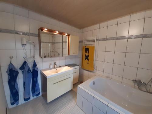 a bathroom with a tub and a sink and a bath tub at Ferienhaus Hunolstein in Morbach