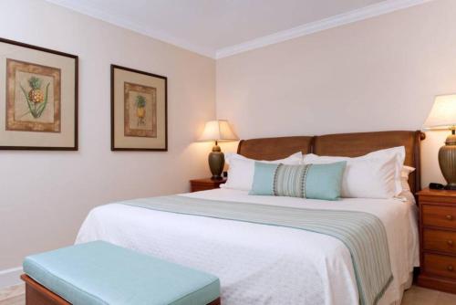 a bedroom with a large white bed with a blue stool at Villa Renaissance Unit 501 Grace Bay Beach in The Bight Settlements