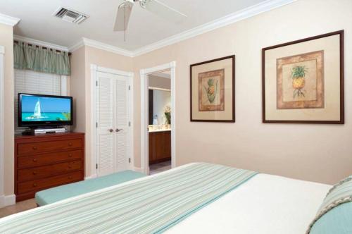 a bedroom with a bed and a flat screen tv at Villa Renaissance Unit 501 Grace Bay Beach in The Bight Settlements