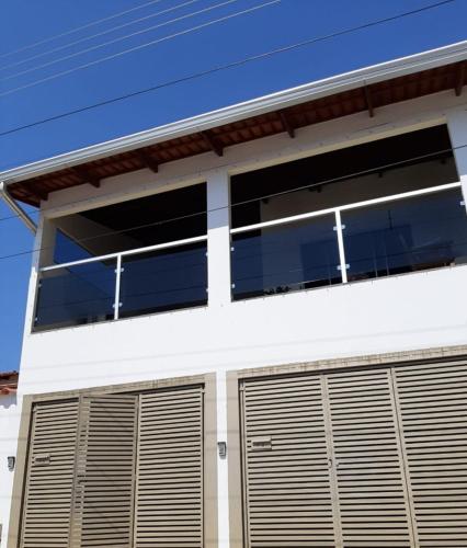 Casa blanca con dos puertas de garaje en Casamatta Hostel - Unidade Aventura en Pirenópolis