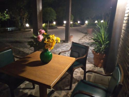 a wooden table with a vase of flowers on it at HOTEL B&B RESORT Fonte La Castellana in Sarnano
