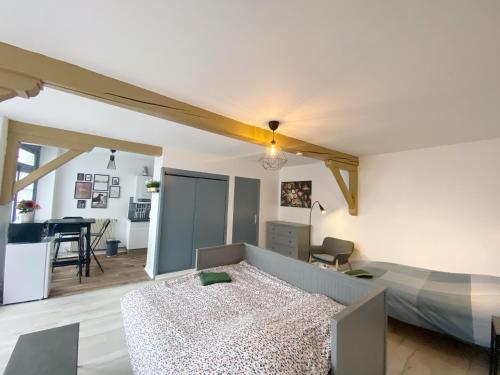 une chambre avec un lit et un bureau dans une pièce dans l'établissement 015 CHIC & COSY STUDIO 41m2 HYPERCENTRE WIFI SMART TV NETFLIX, à Saint-Étienne