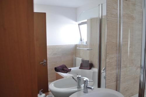 a bathroom with a sink and a shower and a toilet at Casa do Passadiço in Macieira de Sarnes