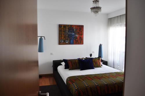 um quarto com uma cama e uma fotografia na parede em Casa do Passadiço em Macieira de Sarnes