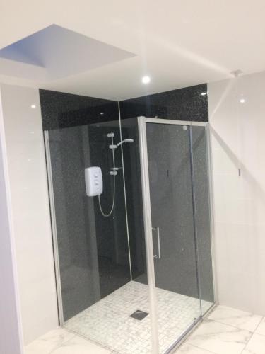 a shower with a glass door in a bathroom at 1 Slieve Gullion View Killeavy Newry in Newry