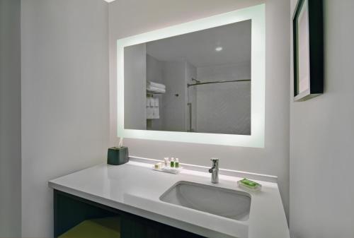 a bathroom with a white sink and a mirror at Holiday Inn Grand Rapids North - Walker by IHG in Walker